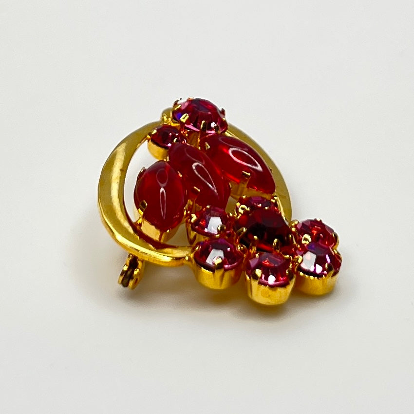 Side angle view of red rhinestone floral brooch with prong-set crystals