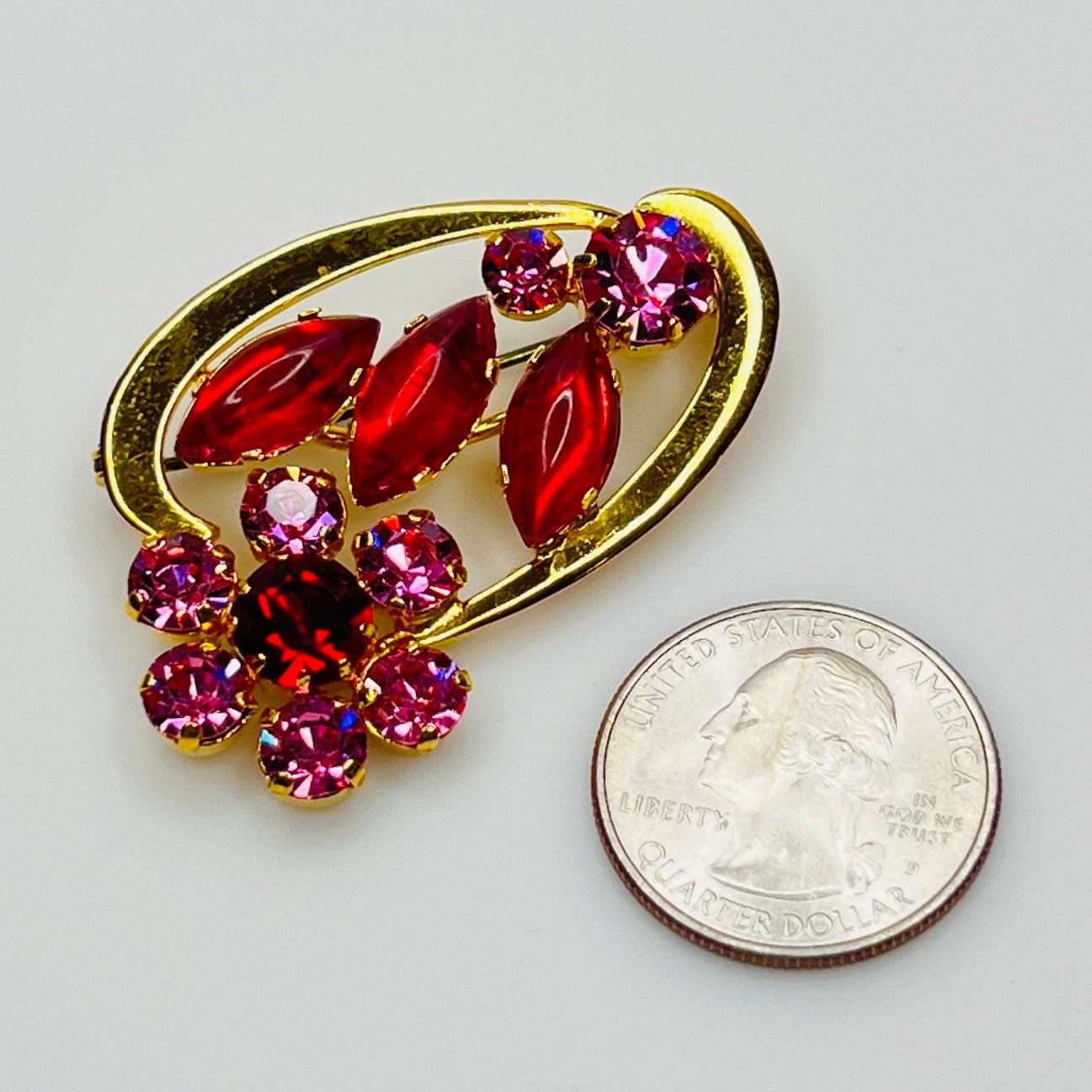 Vintage Austria-stamped brooch shown next to quarter for scale