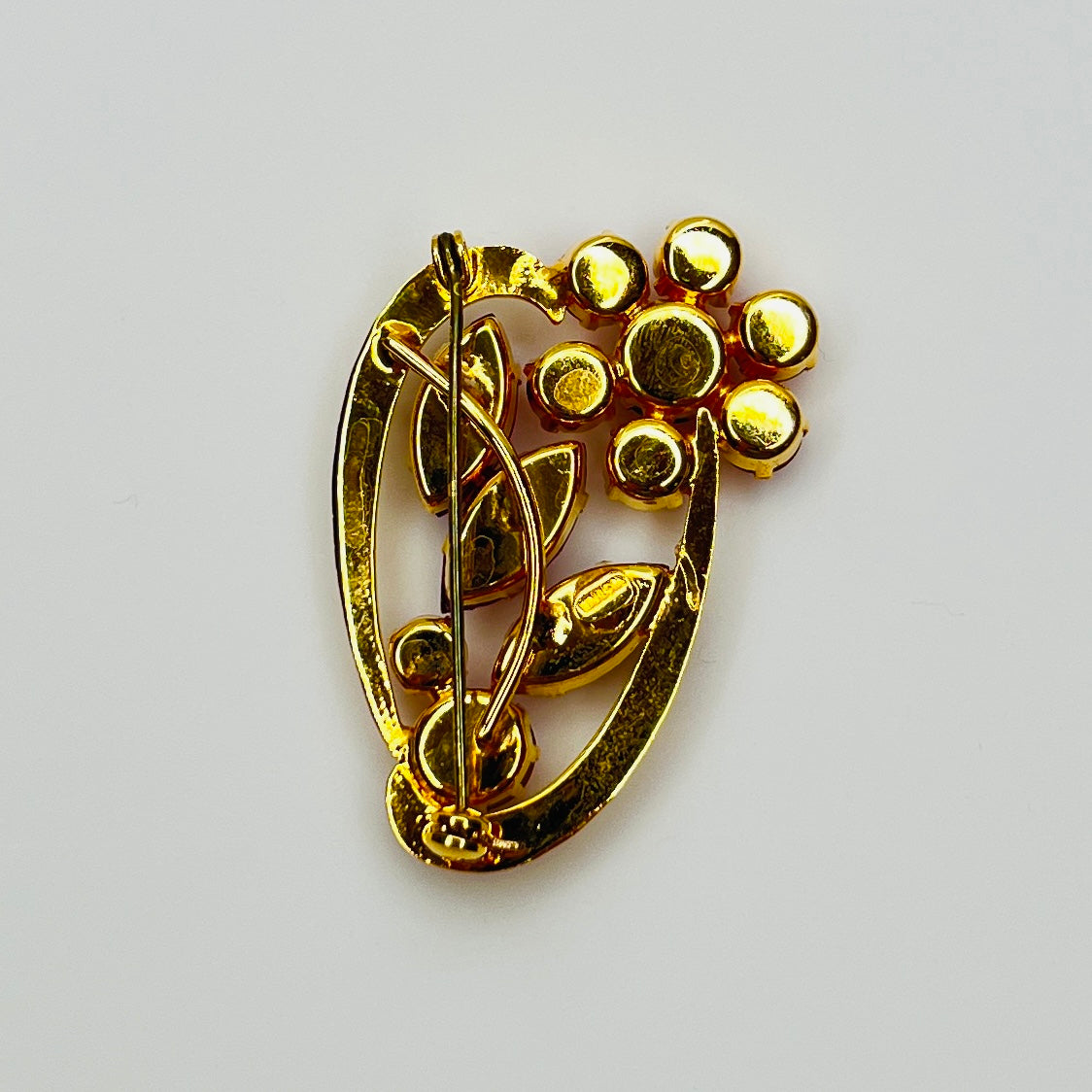 back view of red rhinestone floral brooch with prong-set crystals