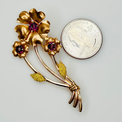 Angled view of vintage flower brooch with purple rhinestones and bouquet styling