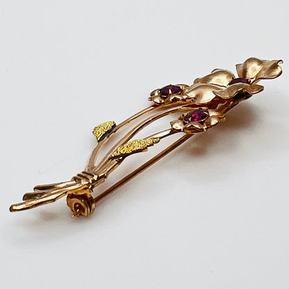 Angled view of vintage flower brooch with purple rhinestones and bouquet styling