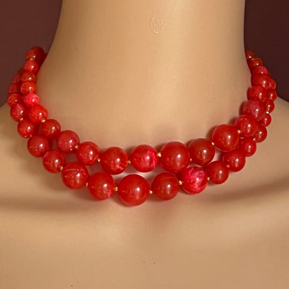 Model wearing 1960s red lucite double-strand necklace in marbled finish