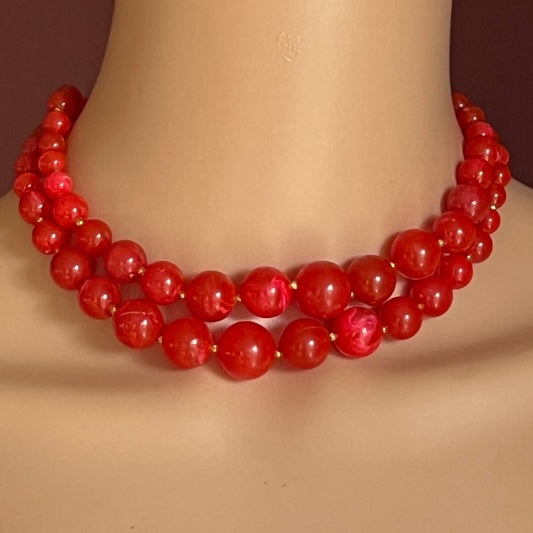 Model wearing 1960s red lucite double-strand necklace in marbled finish