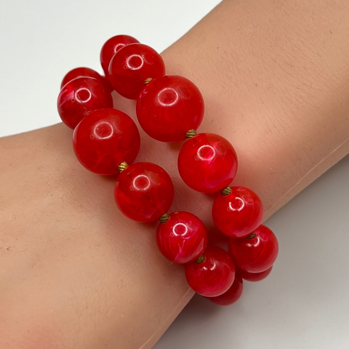 Red lucite wrap bracelet with double strands shown on wrist