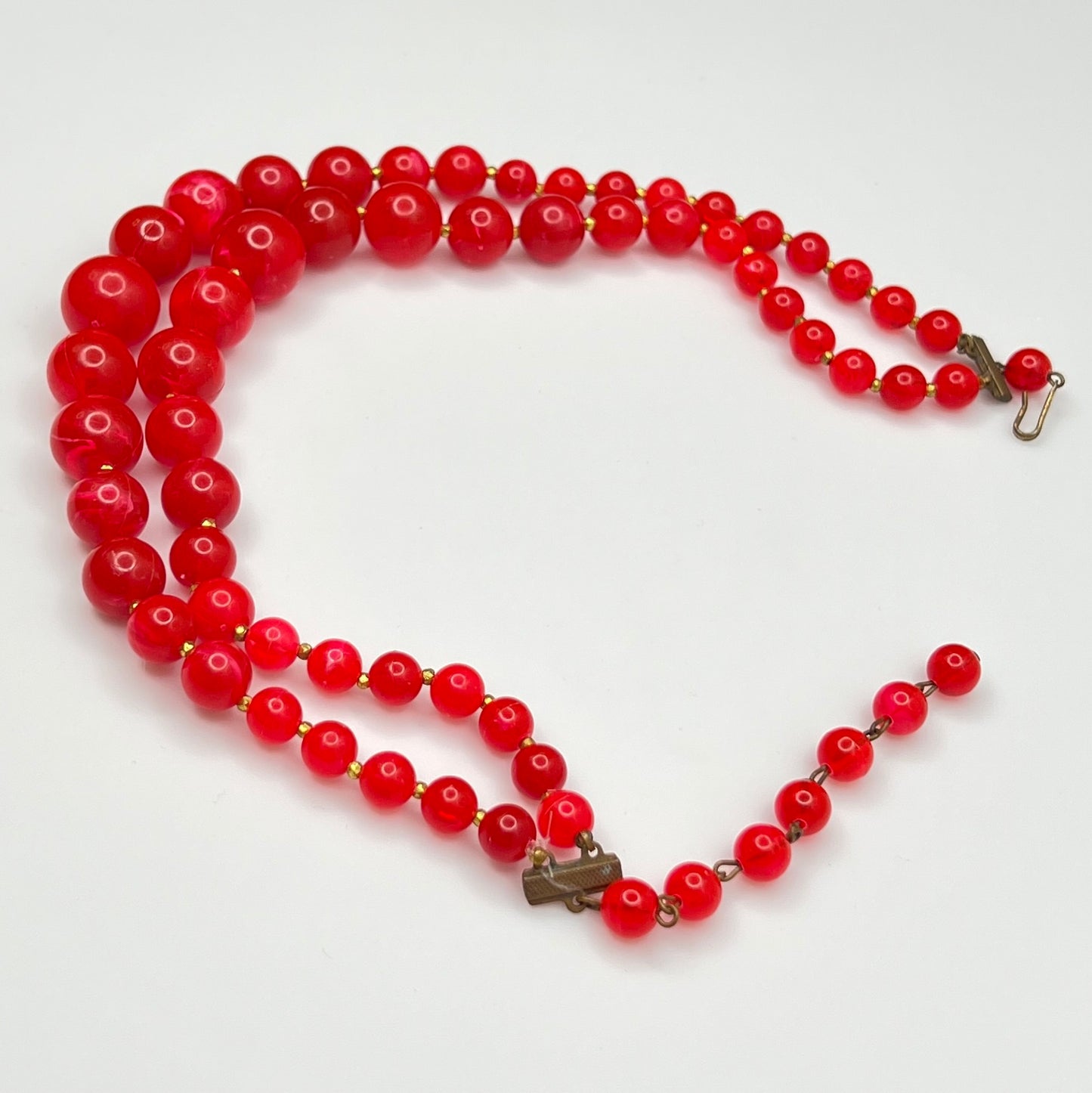 Red lucite beaded necklace on a white background