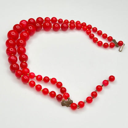 Red lucite beaded necklace on a white background