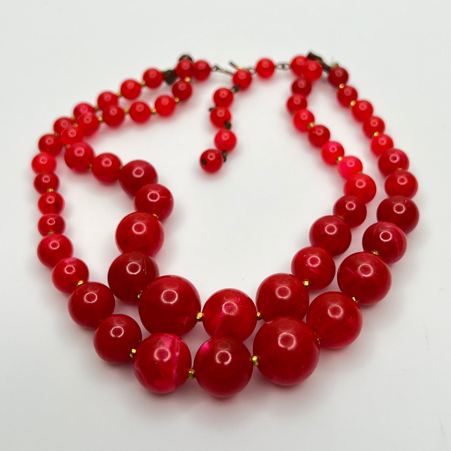 1960s Red lucite beaded necklace on a white background