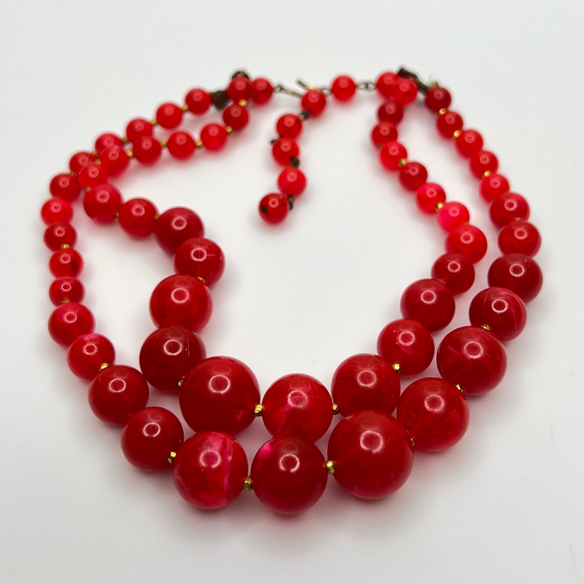1960s Red lucite beaded necklace on a white background