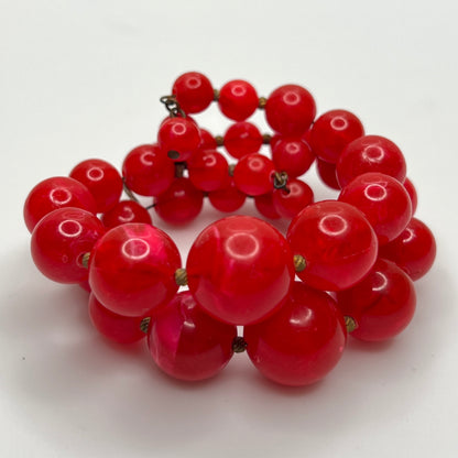 1960s Red lucite beaded bracelet on a white background