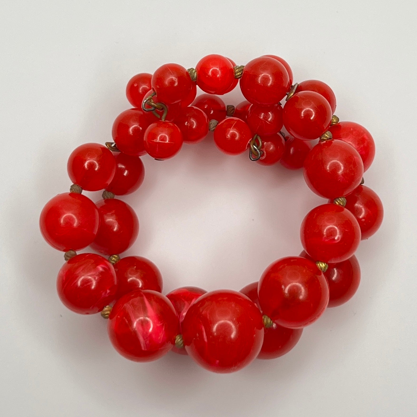 1960s Red lucite beaded bracelet on a white background