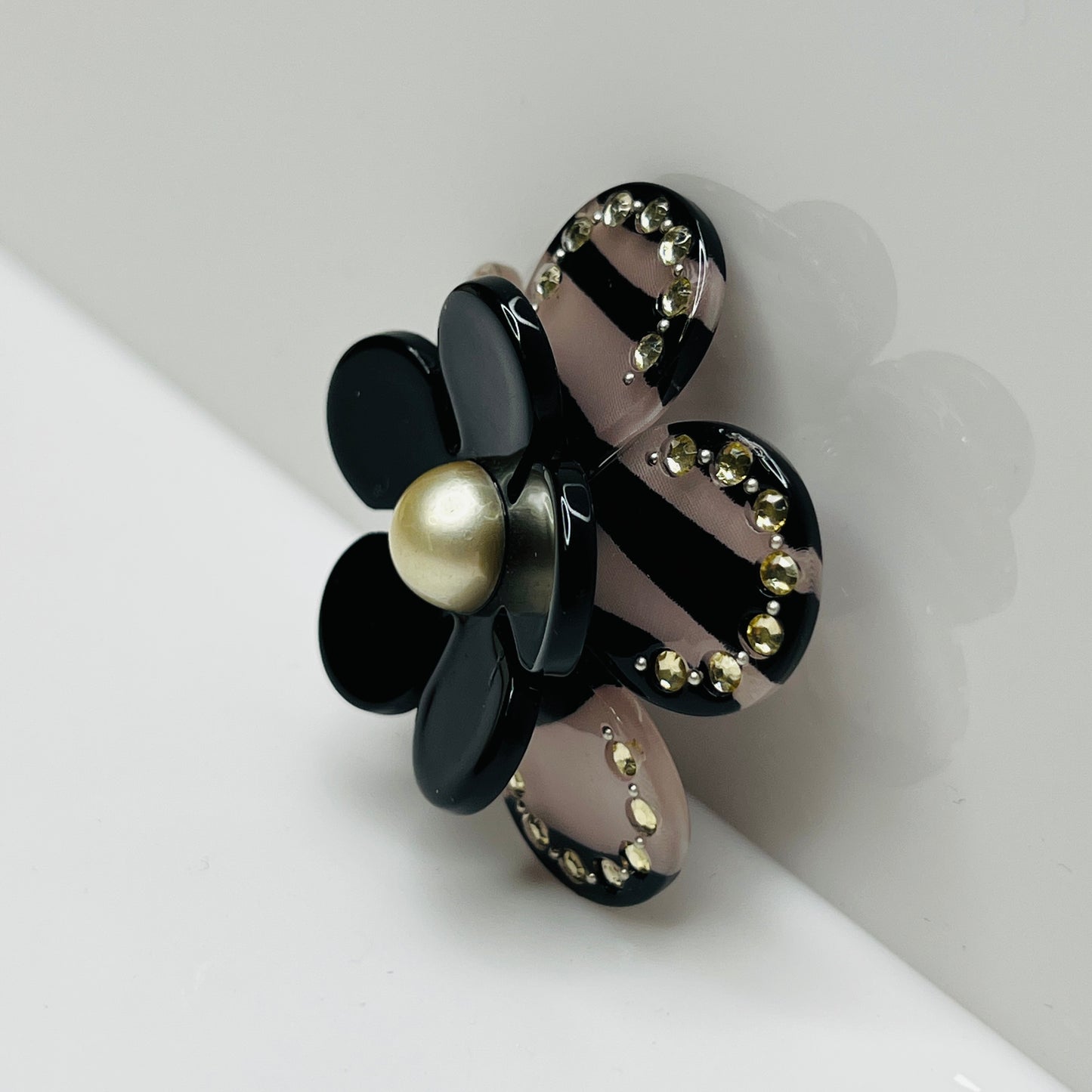 Layered mod-era flower brooch in black and clear Lucite