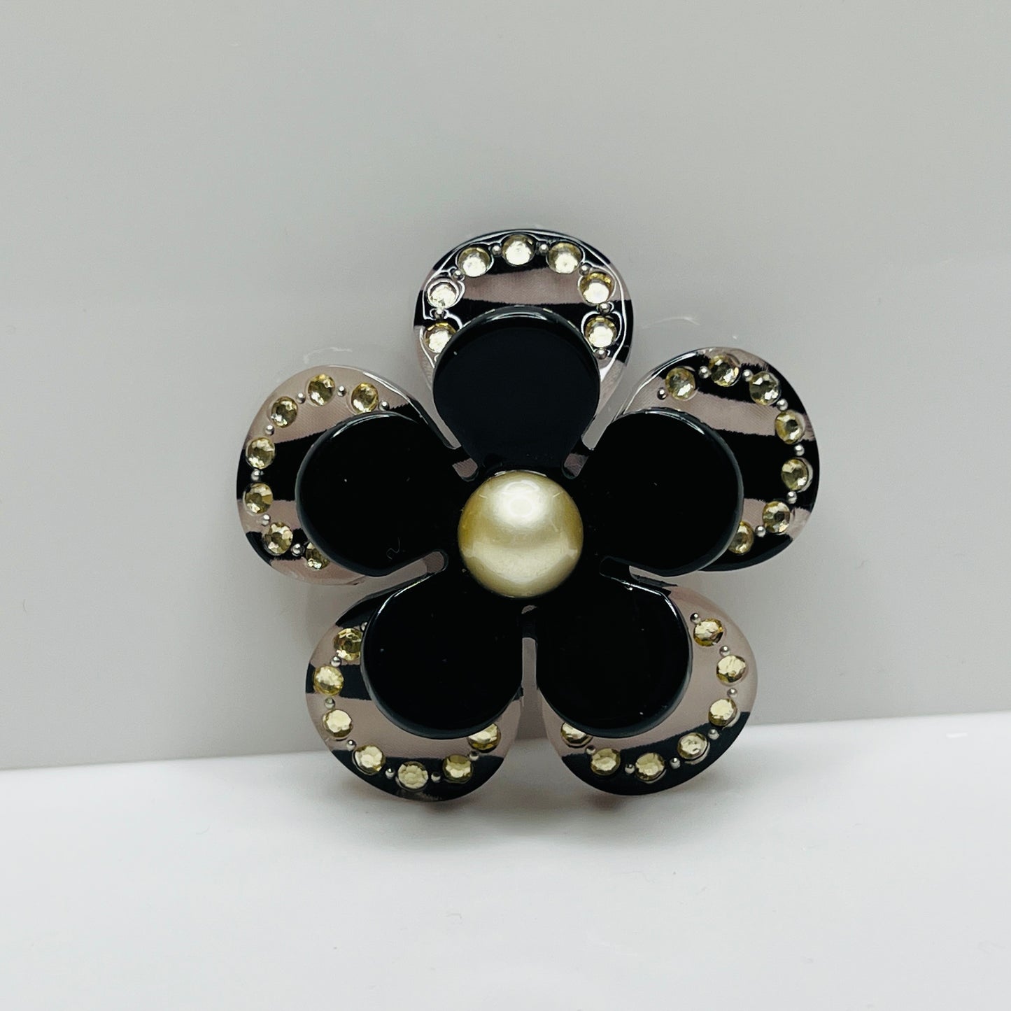 1970s black Lucite flower brooch with rhinestones and pearl center