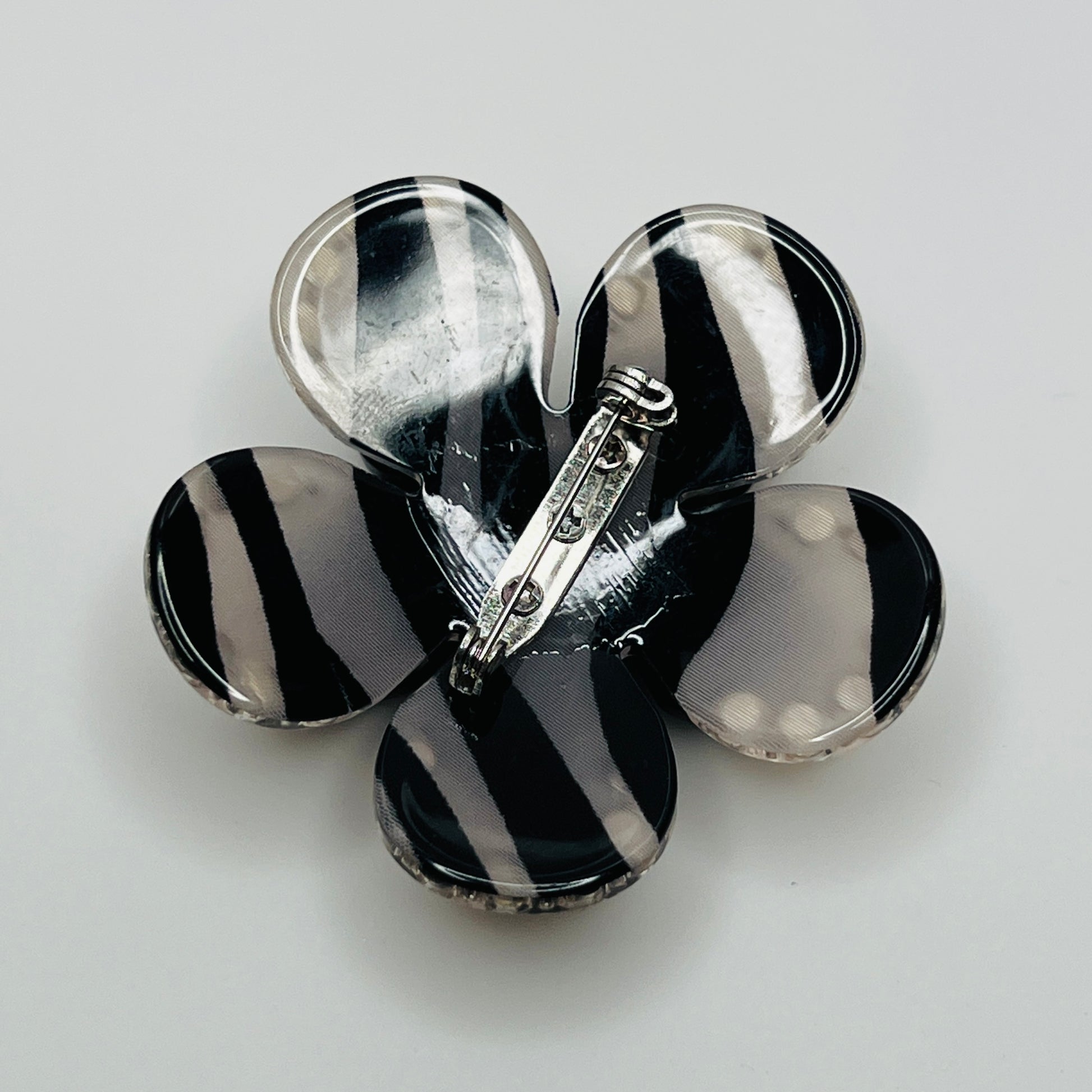 1970s black Lucite flower brooch with rhinestones and pearl center