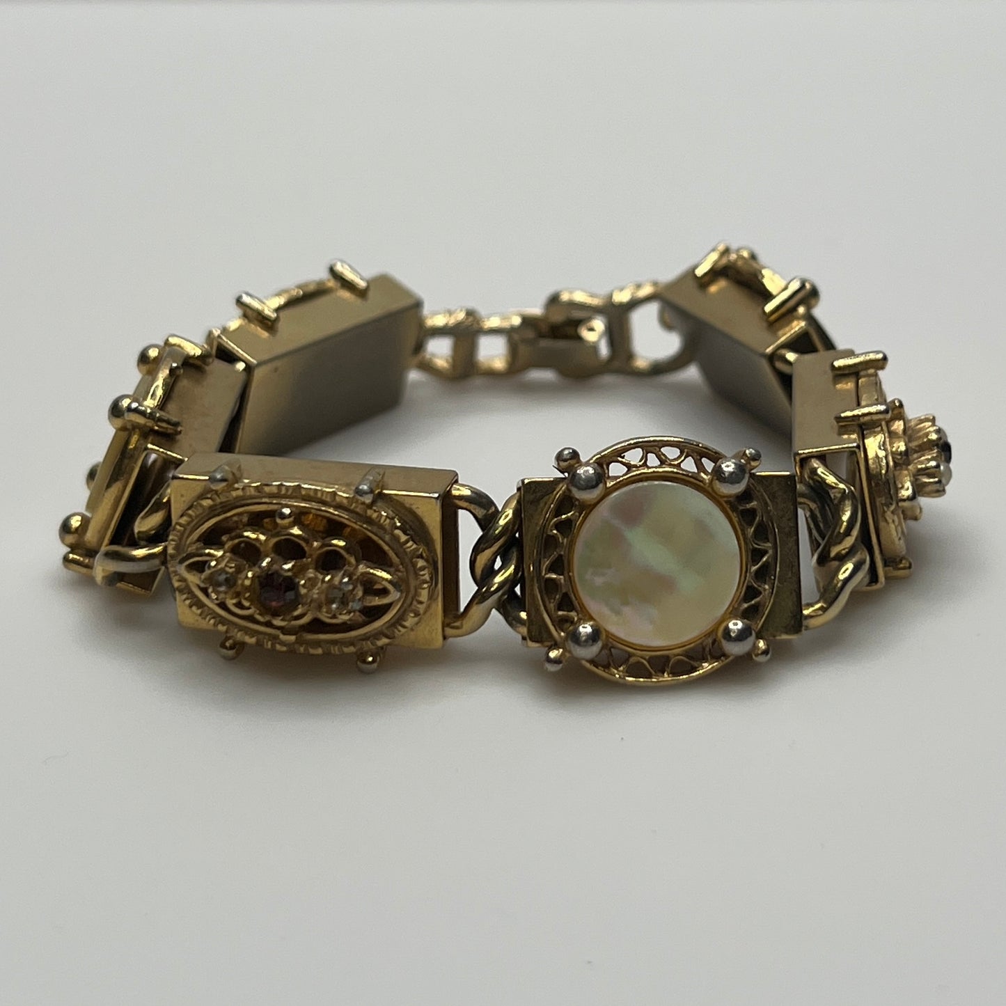 Ornate vintage gold link bracelet with hinged clasp and purple rhinestones