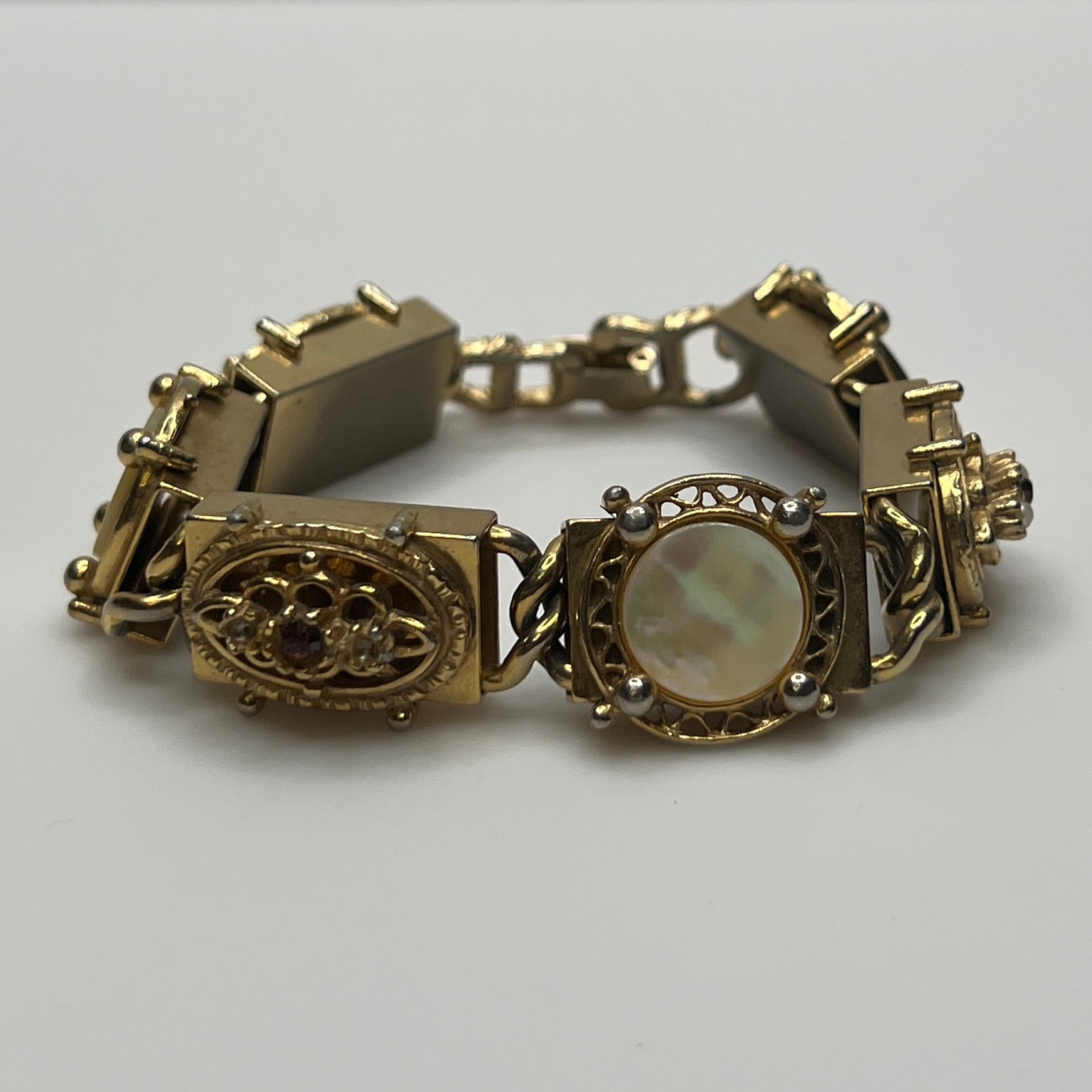 Ornate vintage gold link bracelet with hinged clasp and purple rhinestones