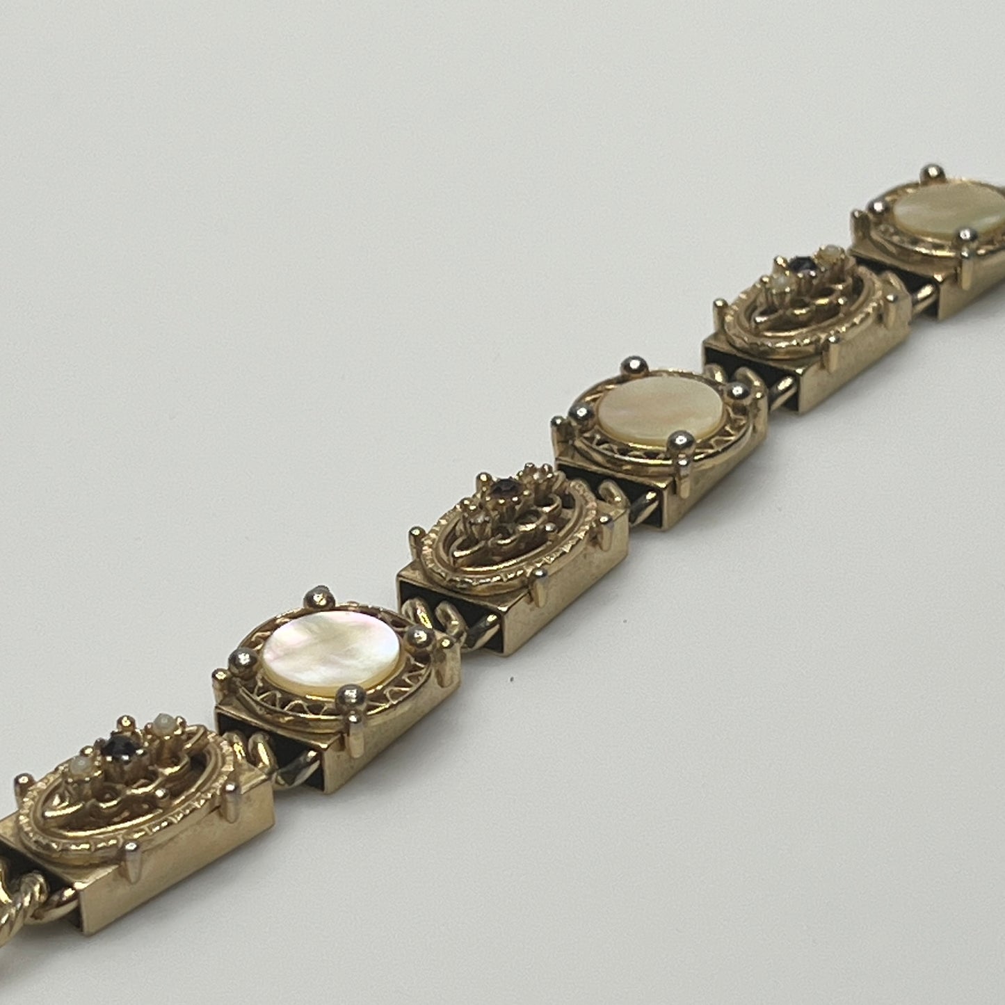 Ornate vintage gold link bracelet with hinged clasp and purple rhinestones