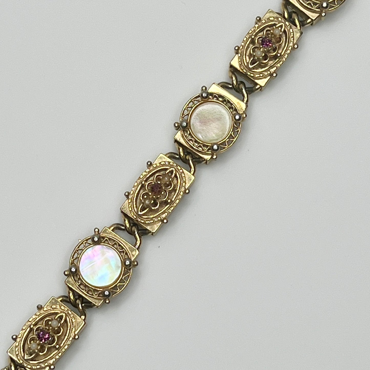 Ornate vintage gold link bracelet with hinged clasp and purple rhinestones