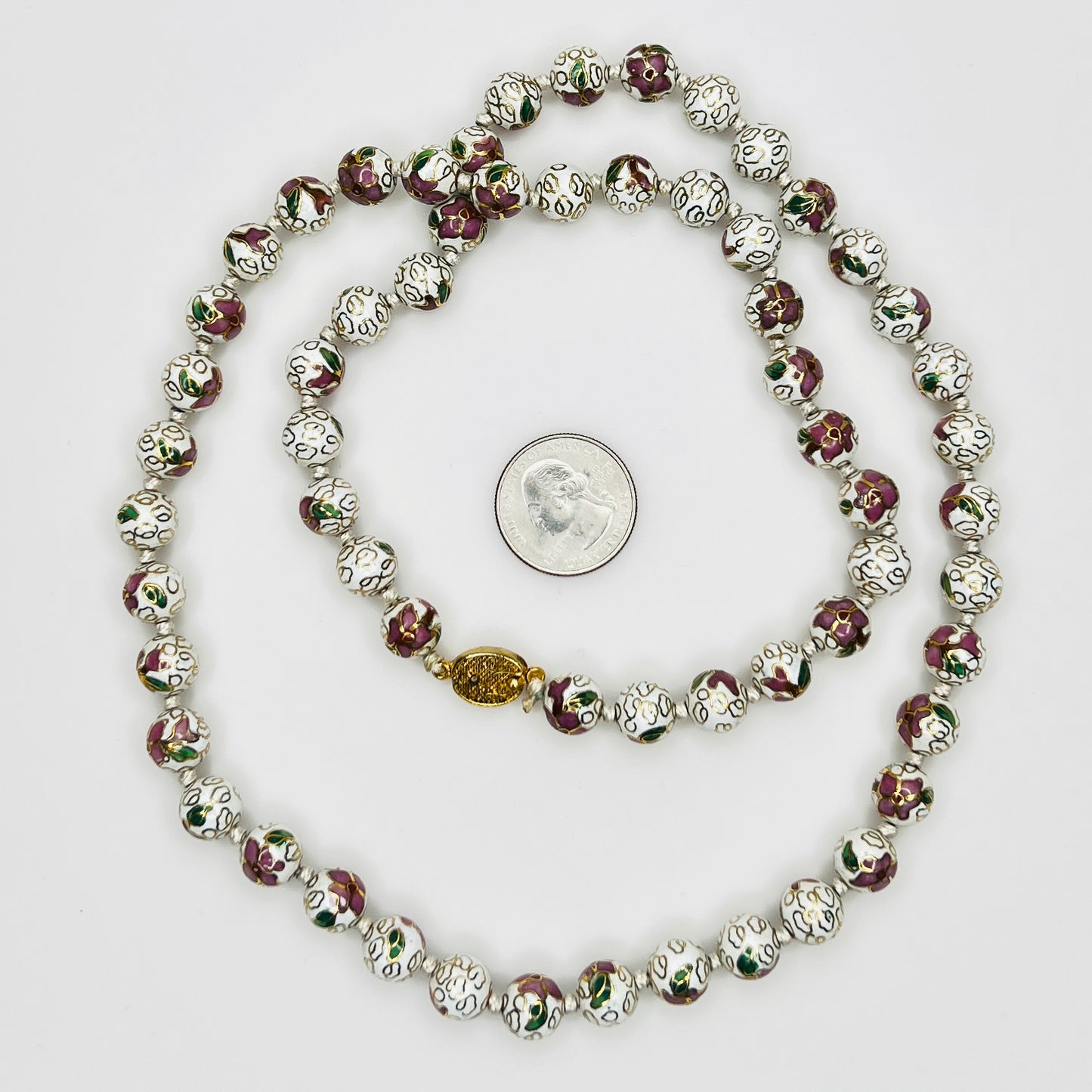 Close-up of plum and white floral enamel beads and box clasp