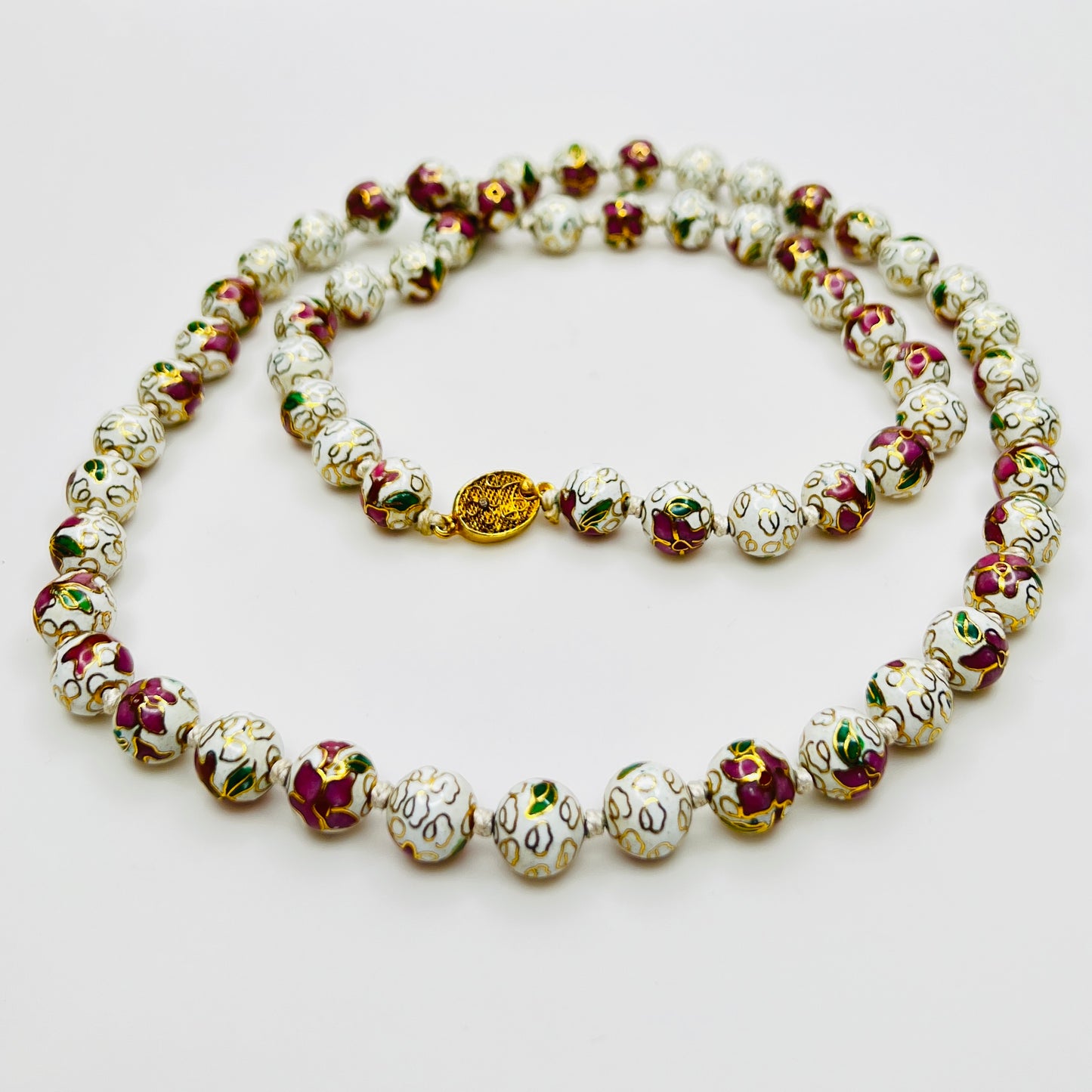 Close-up of plum and white floral enamel beads and box clasp