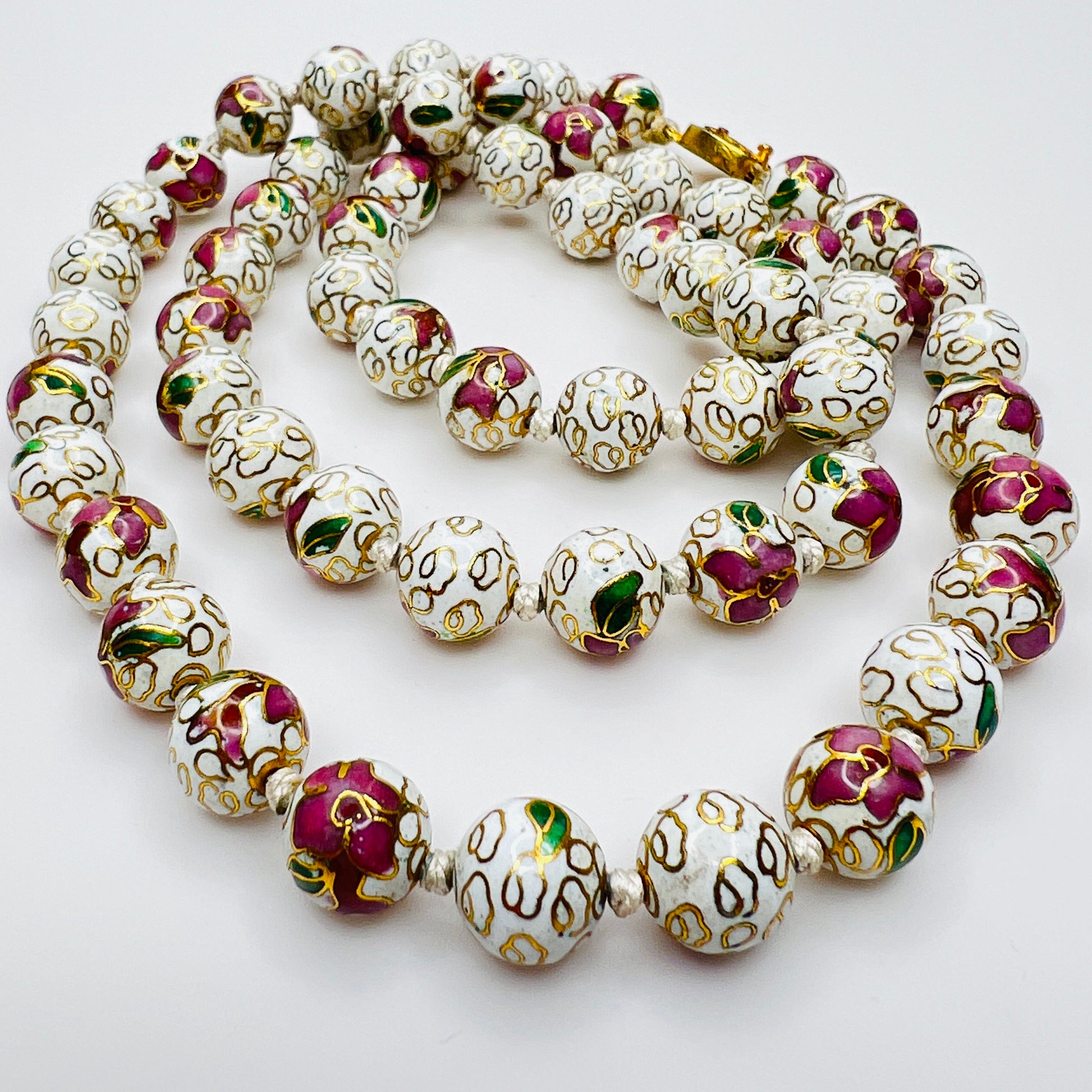 Close-up of plum and white floral enamel beads and box clasp