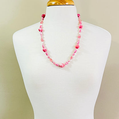 Pastel pink vintage glass necklace on mannequin, mid-length with soft mod styling
