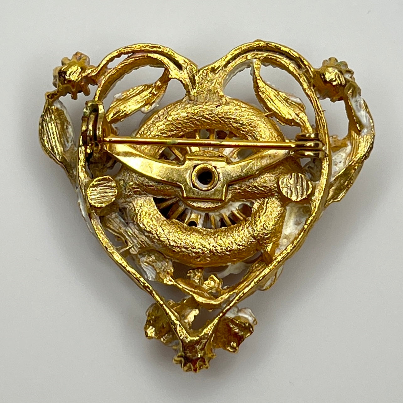 Reverse of brooch with gold-tone setting and secure pin back