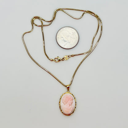 Close-up of oval pink cameo in 14K gold frame