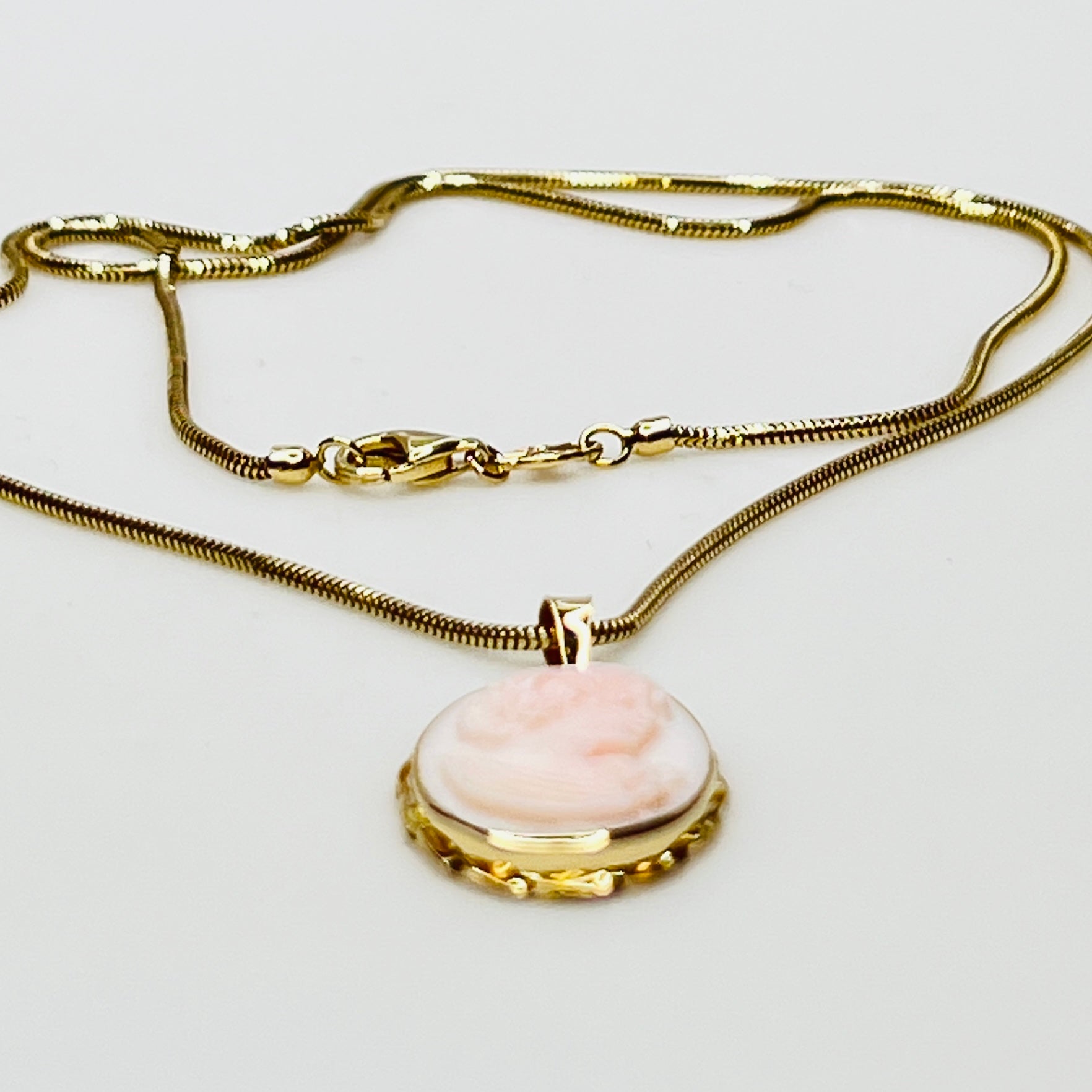Close-up of oval pink cameo in 14K gold frame