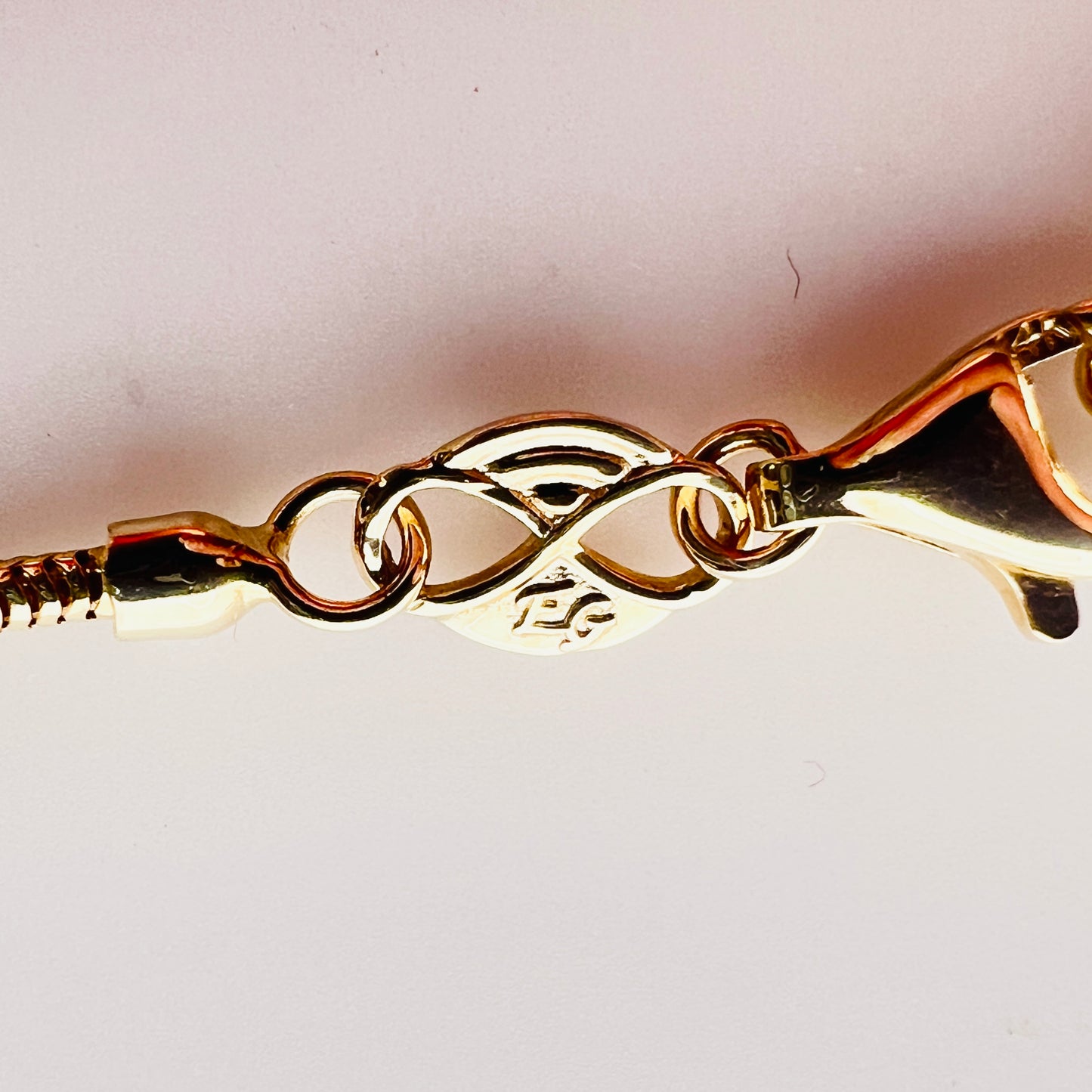 Close-up of 14K Italy clasp and snake chain detail
