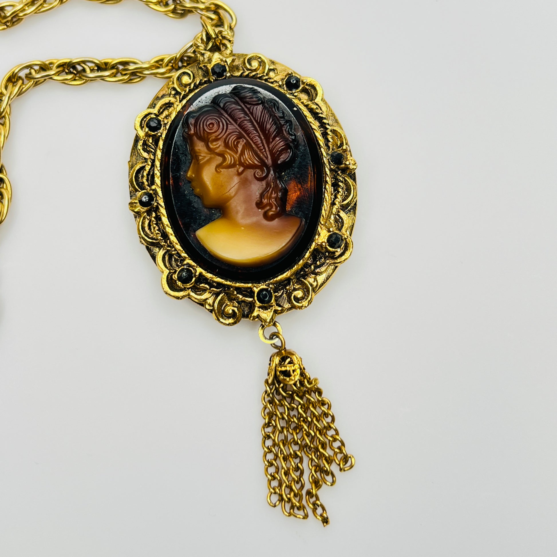 Close-up of amber glass cameo in ornate gold frame