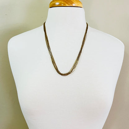 Gold tone liquid silver necklace displayed on mannequin