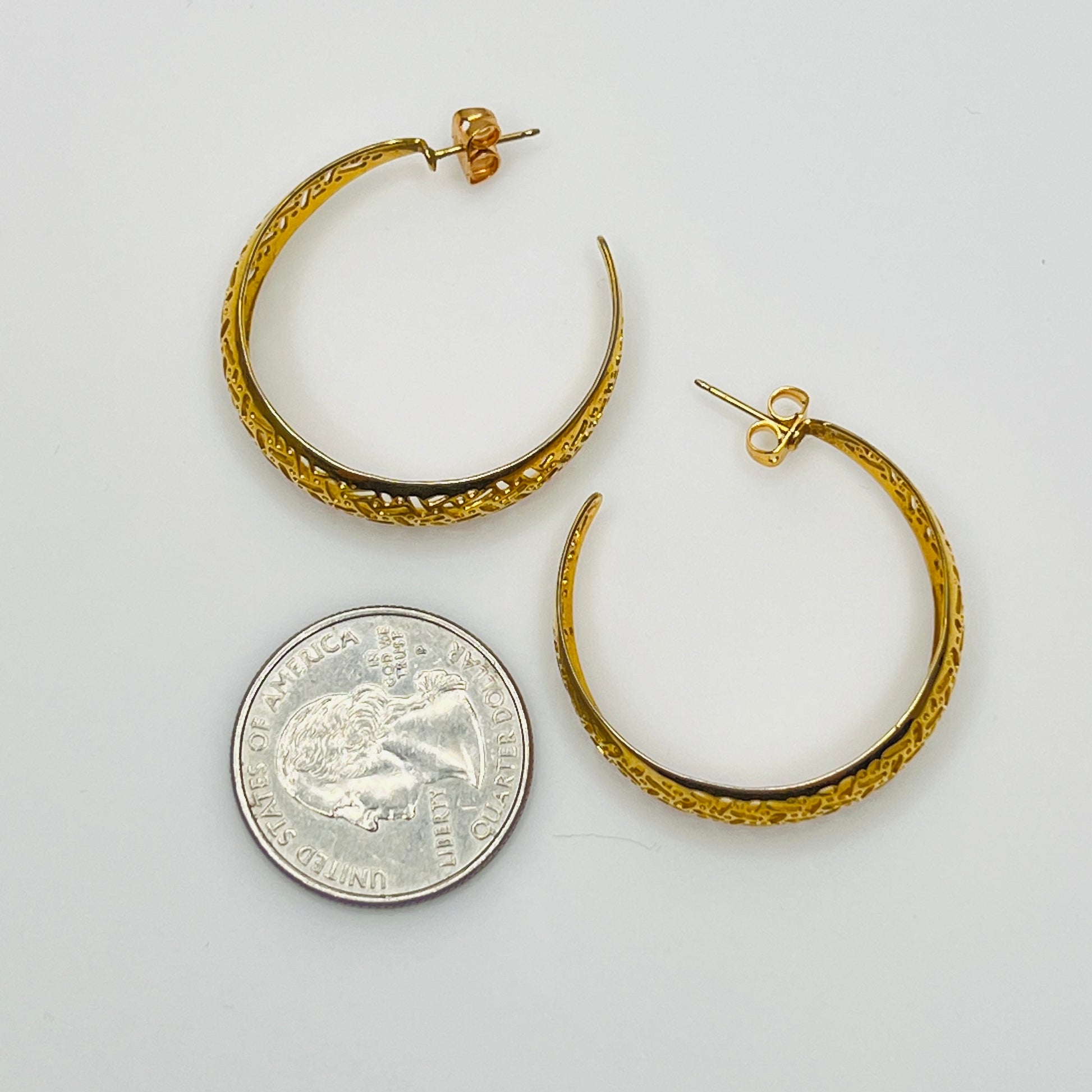 Domed gold-tone hoops with intricate lattice design, side view