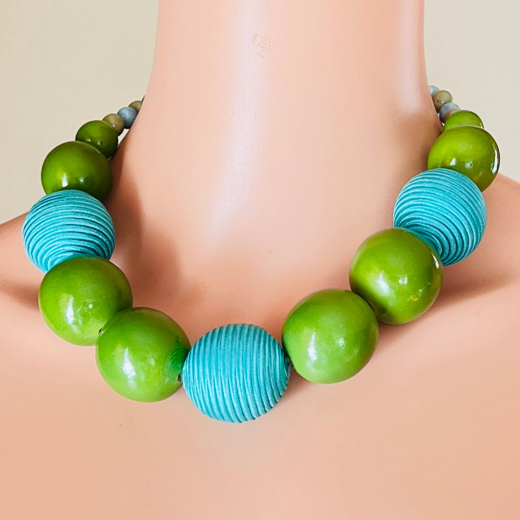 Bold 1980s green and blue beaded statement necklace on mannequin