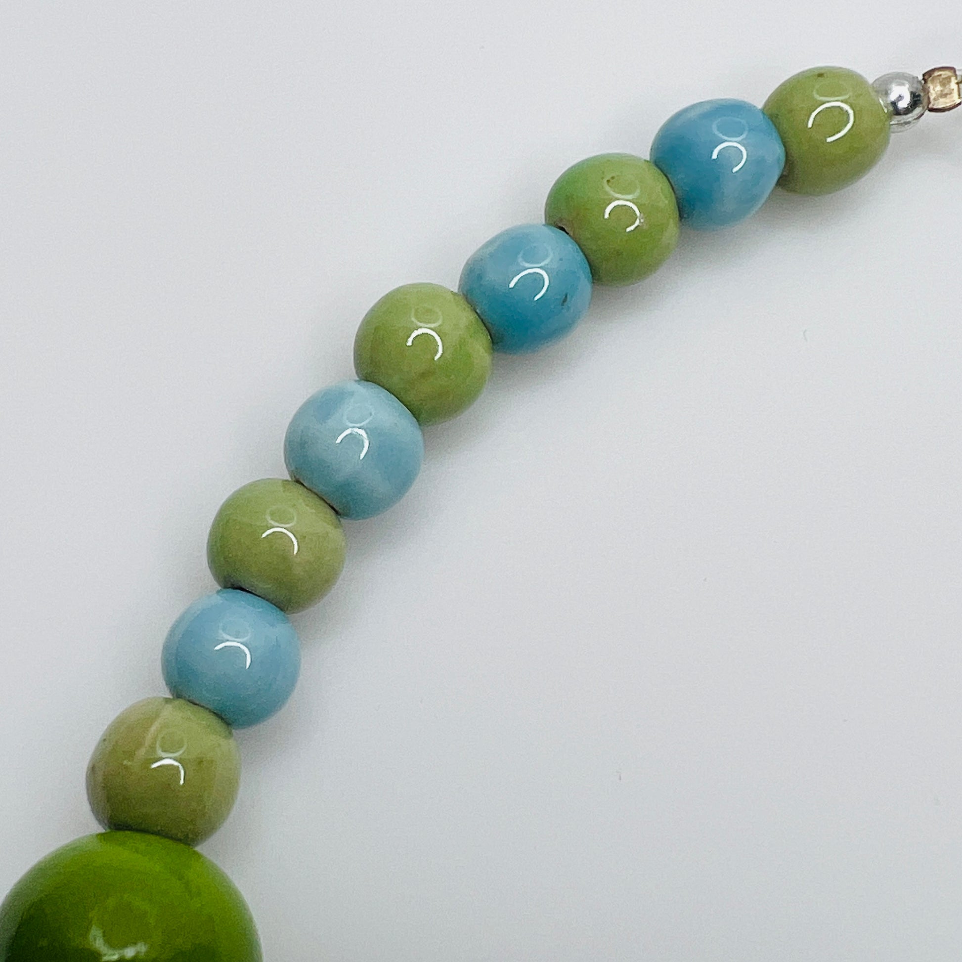 Close-up of smaller blue and green ceramic beads at back