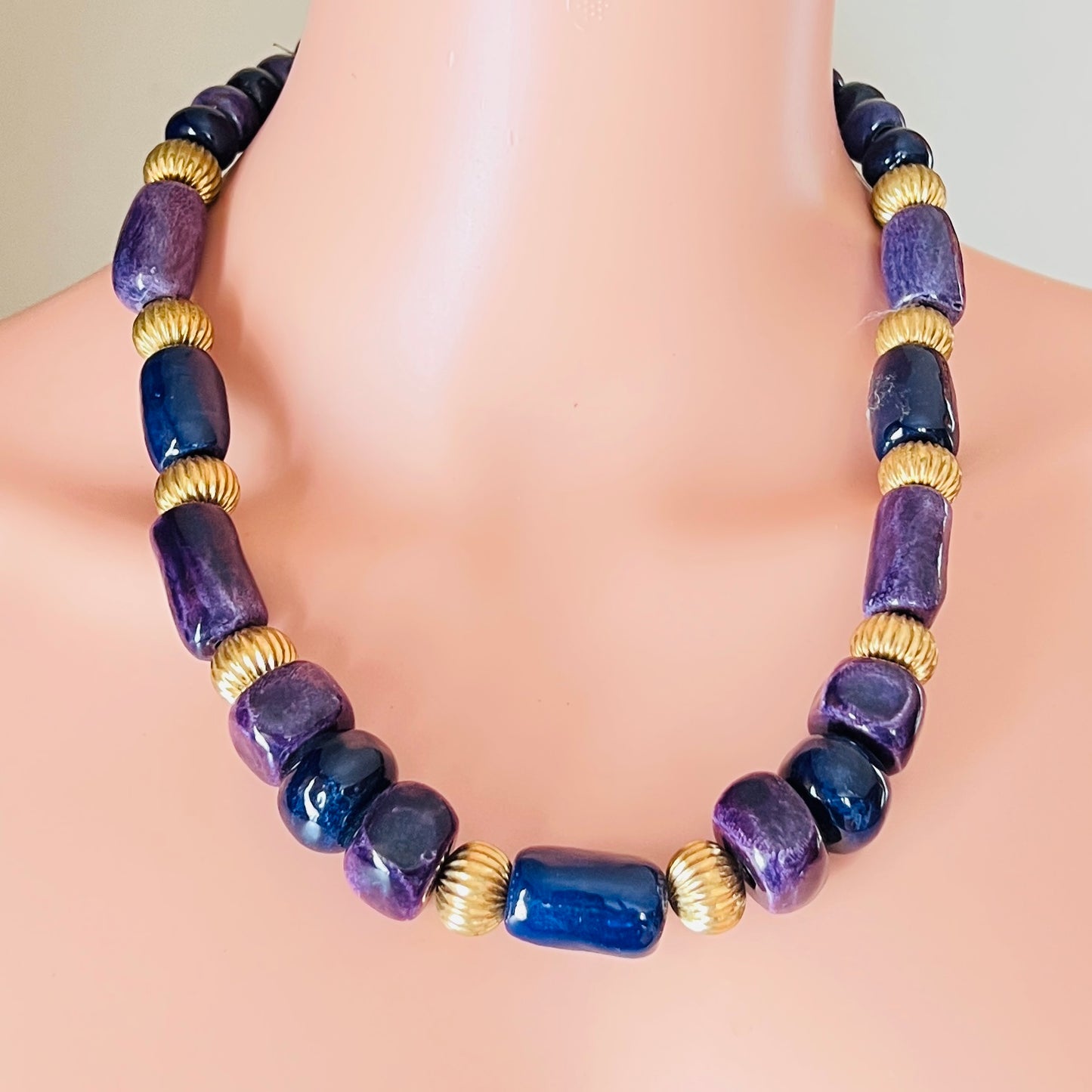 Vintage statement necklace worn on mannequin with violet and navy ceramic beads