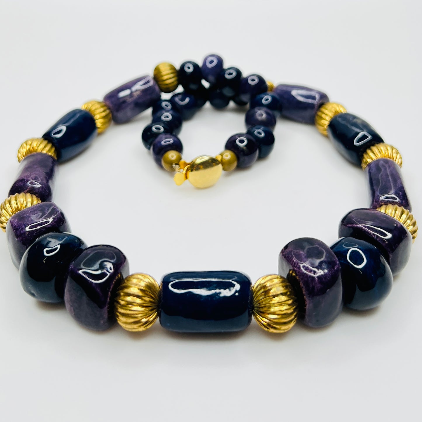 Close-up of gold tone box clasp and glossy ceramic beads, 21 inch necklace