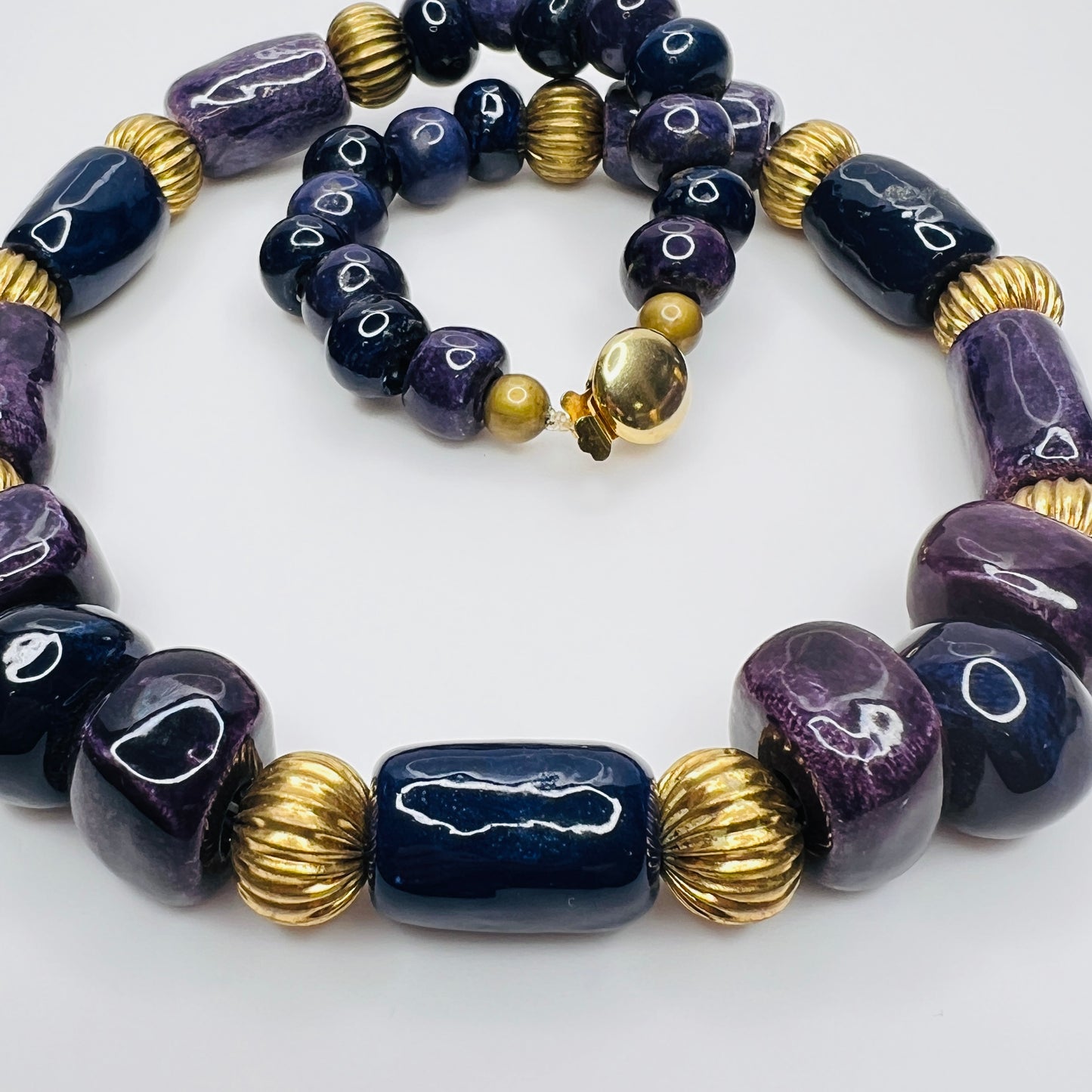 Close-up of gold tone box clasp and glossy ceramic beads, 21 inch necklace