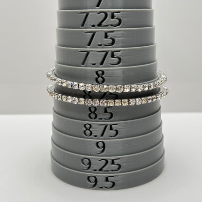 Set of two silver-tone bangle bracelets with prong-set clear rhinestones, vintage 1980s.