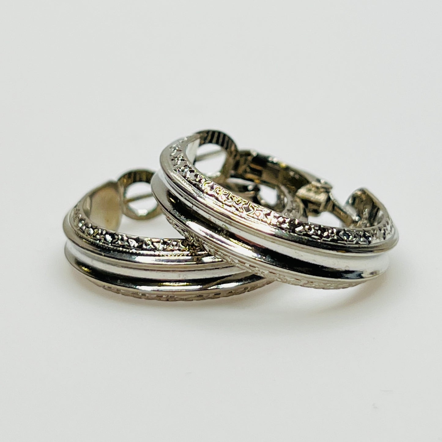 Close-up of vintage silver leverback hoop earrings, textured design