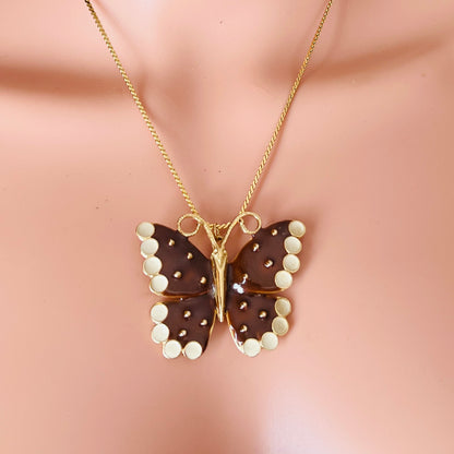 Butterfly-shaped pendant necklace on a mannequin with a beige background