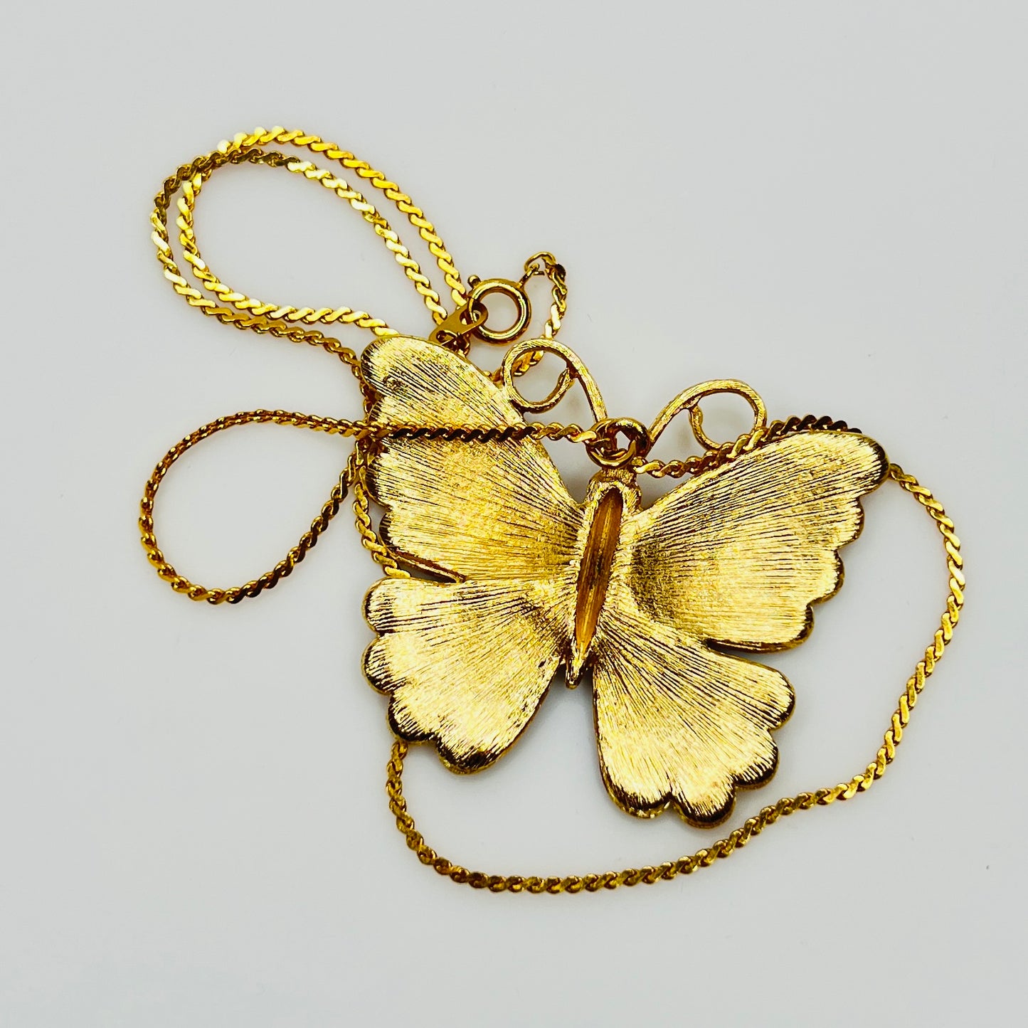 Back of gold tone butterfly pendant with textured finish