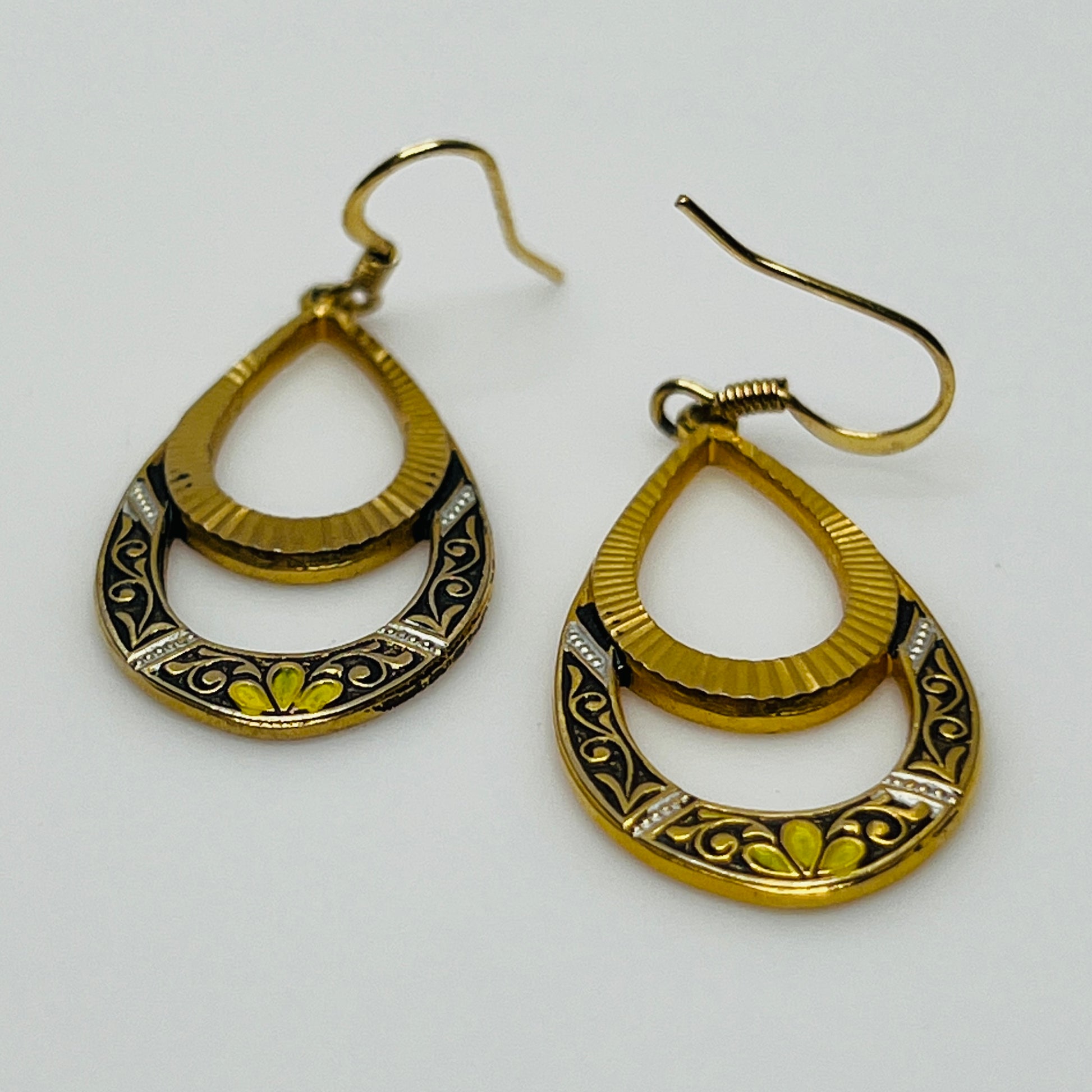 Retro-style open teardrop earrings with yellow, black, and white enamel