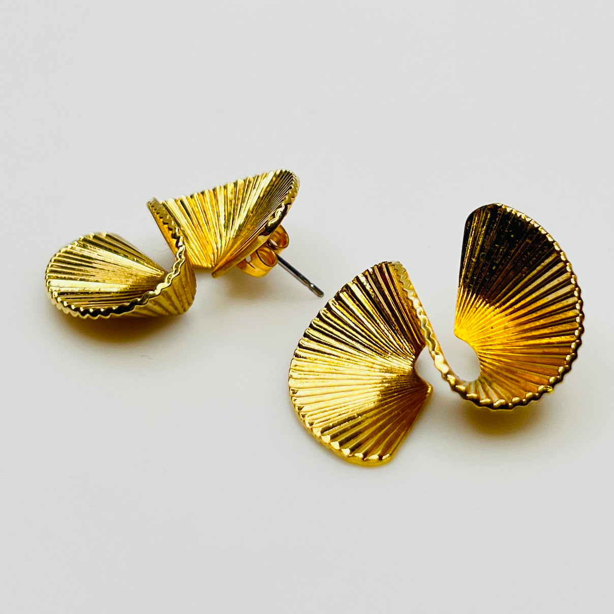 Gold tone sculptural swirl pierced stud earrings