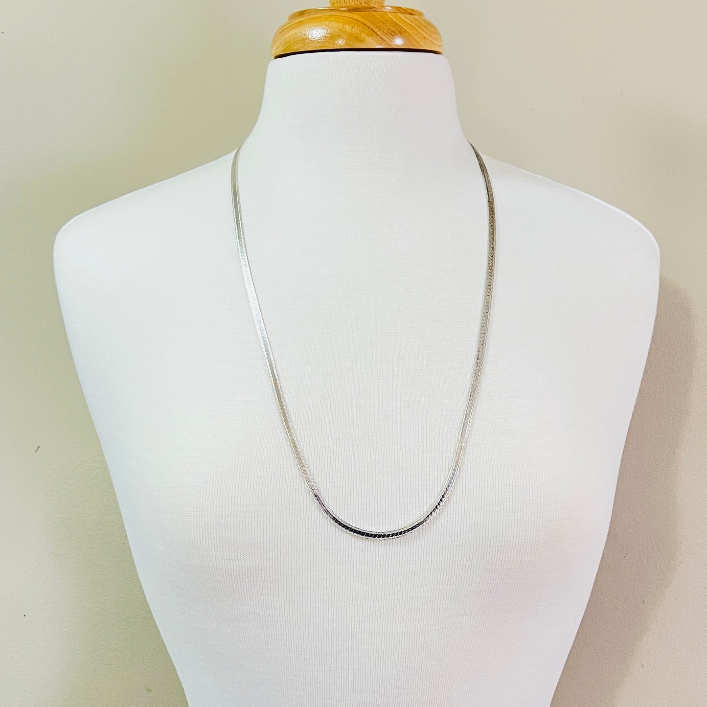 Vintage sterling silver snake chain necklace displayed on jewelry bust