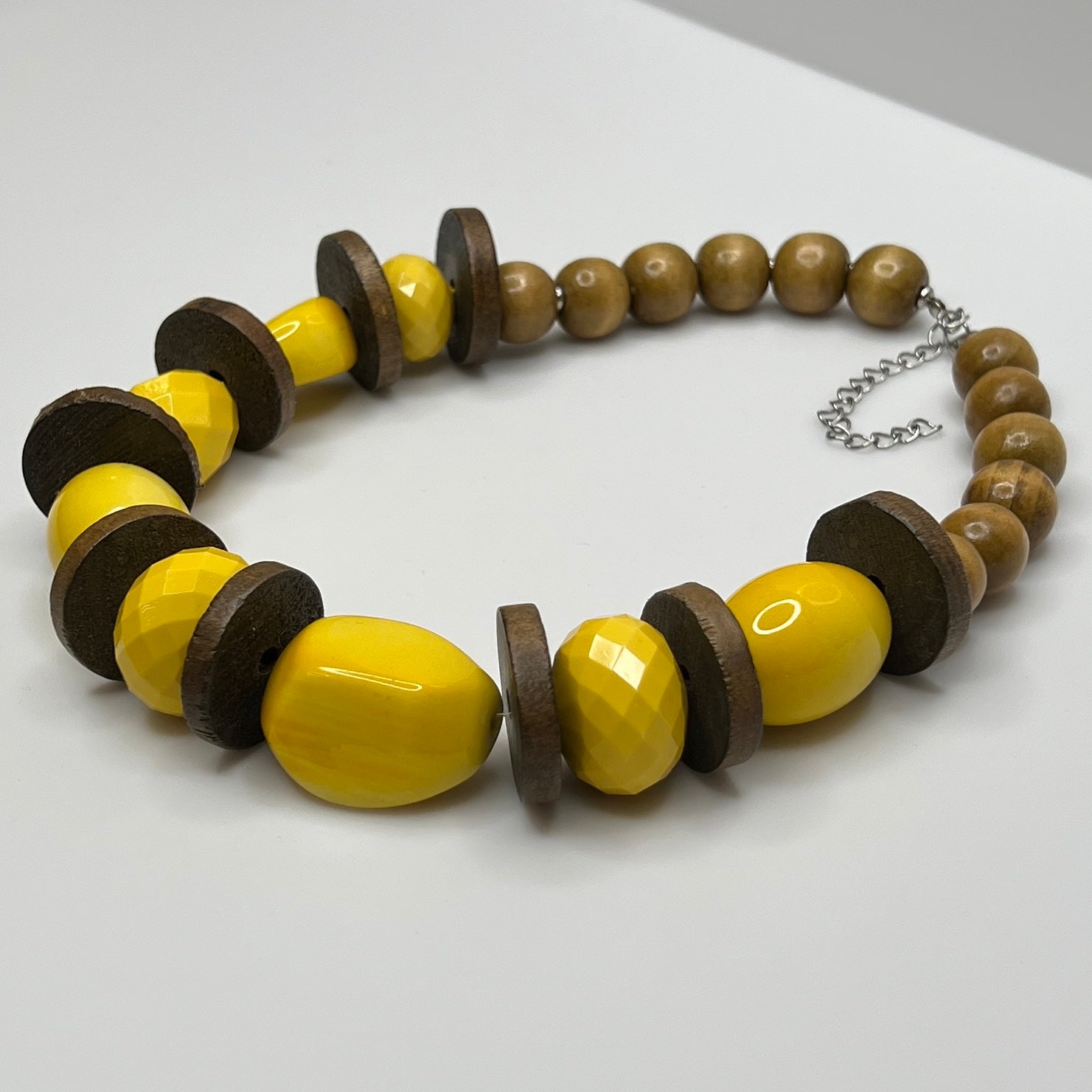 Close-up of 1" wooden disc spacers and glossy yellow lucite