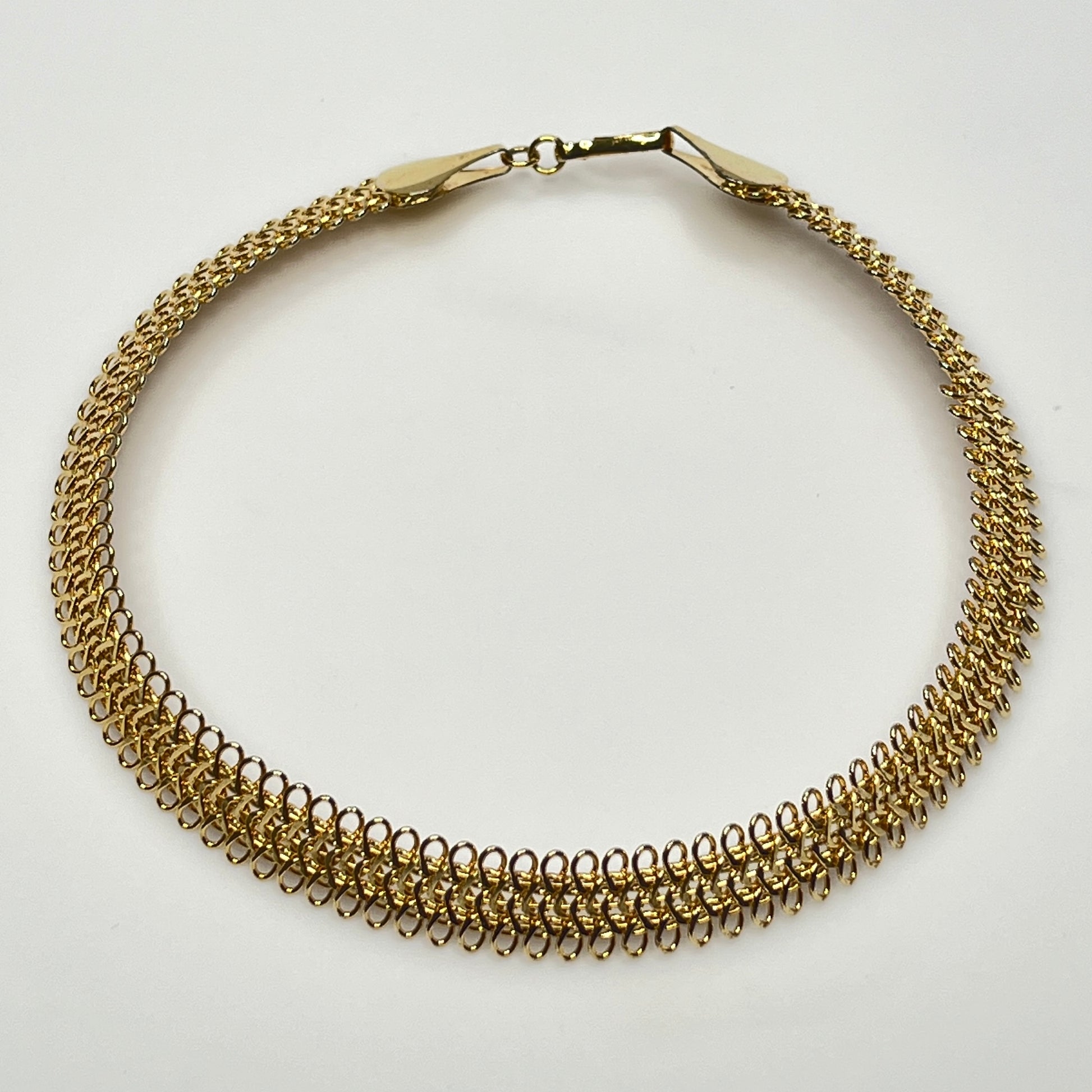 Close-up of looped gold wire choker with hook clasp
