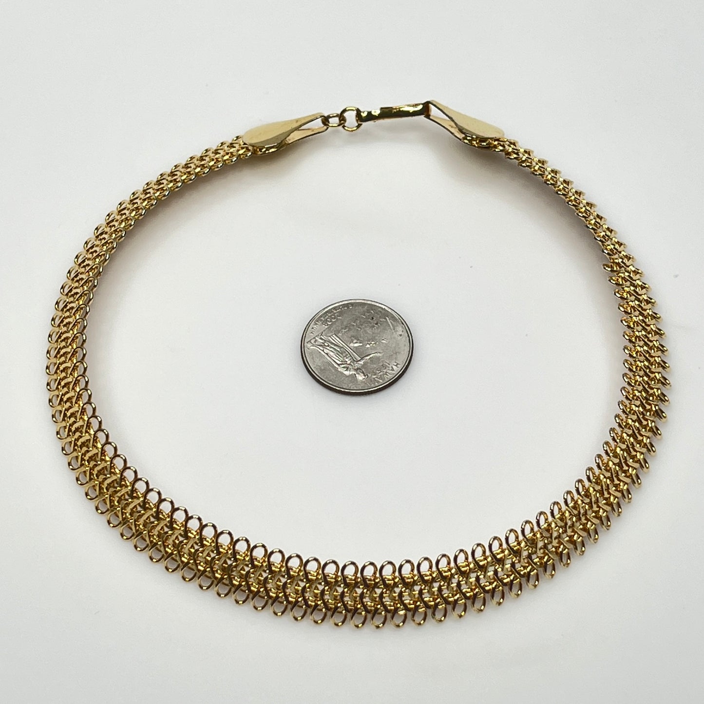 Close-up of looped gold wire choker with hook clasp