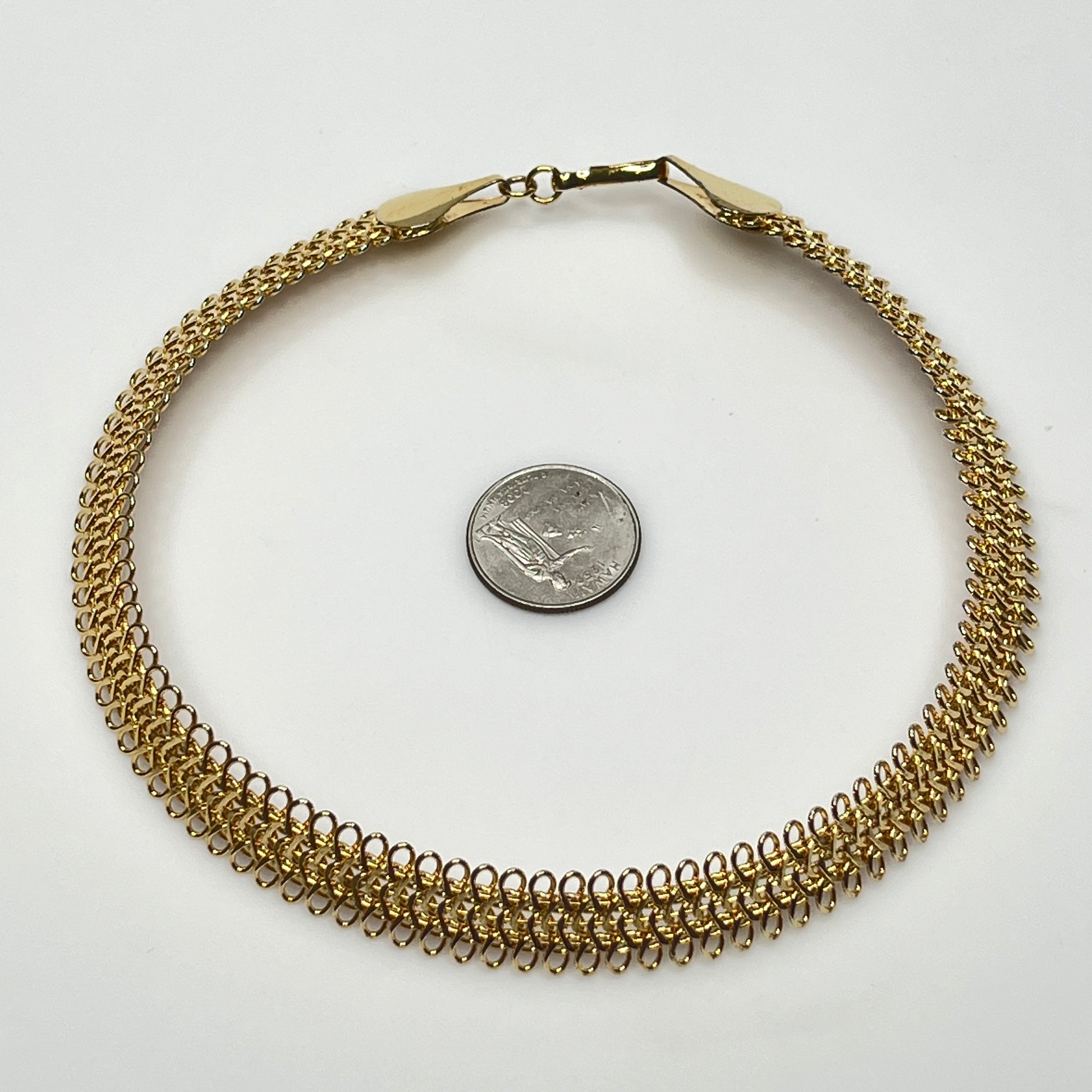 Close-up of looped gold wire choker with hook clasp