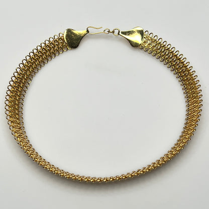 Close-up of looped gold wire choker with hook clasp
