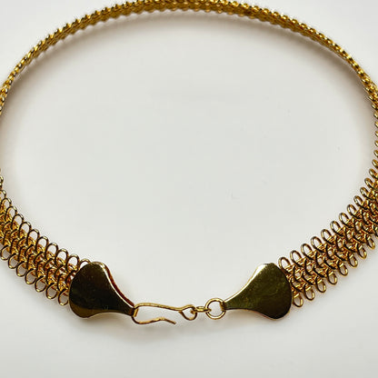 Close-up of looped gold wire choker with hook clasp